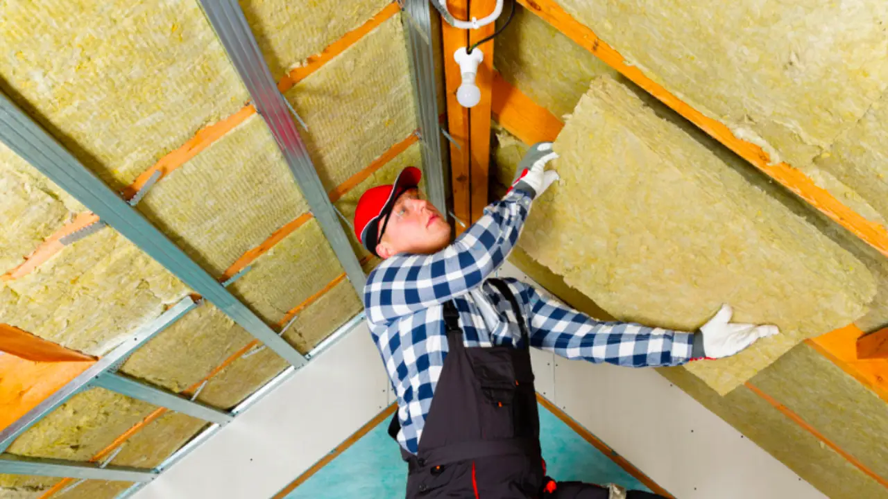 A worker making an attic insulation